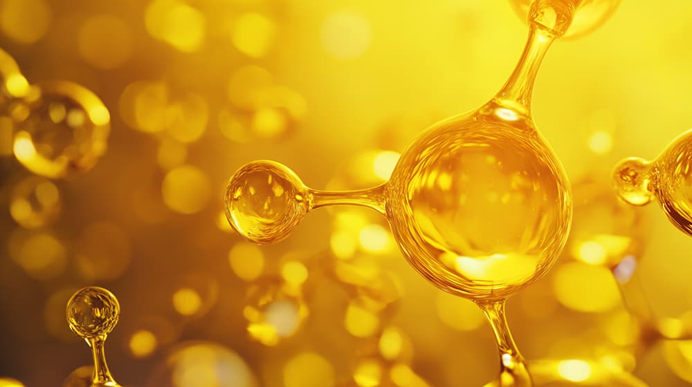 Close-up of golden, liquid-like 3D molecular structures on a glowing yellow background, illustrating deuterated drug molecules